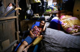 Richel Mangampo (L) sleeps beside her children Jalian and Sherwin at their house in Manila 